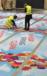 People in the banner sign factory making your advertising bright with flowers for spring clean special event.