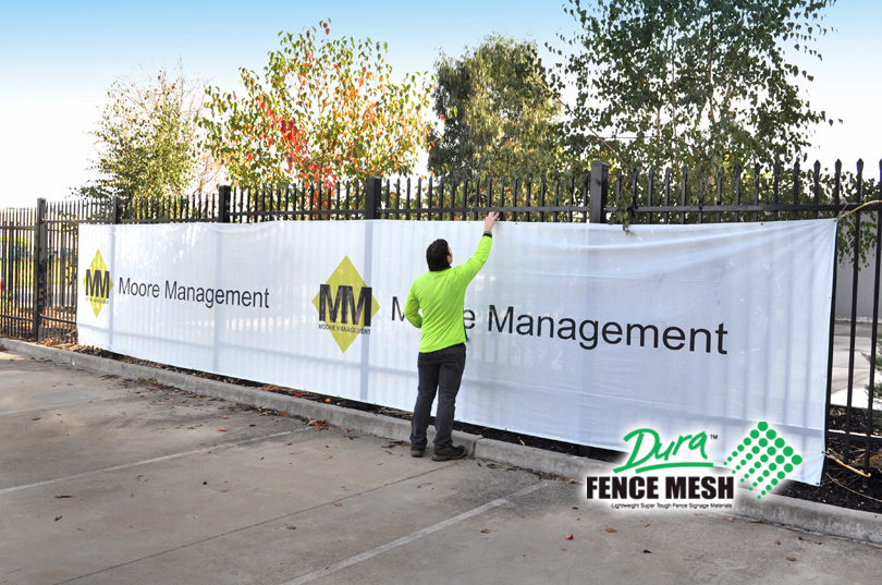 Site screens for temporary fence hire, large printed fence mesh banner fitted. White with company logo printed on banner.