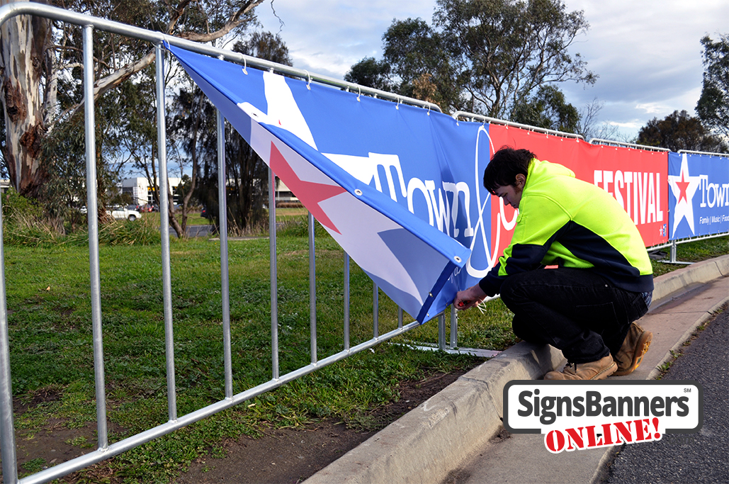 Attaching lots of banner signs to the fences with zip ties