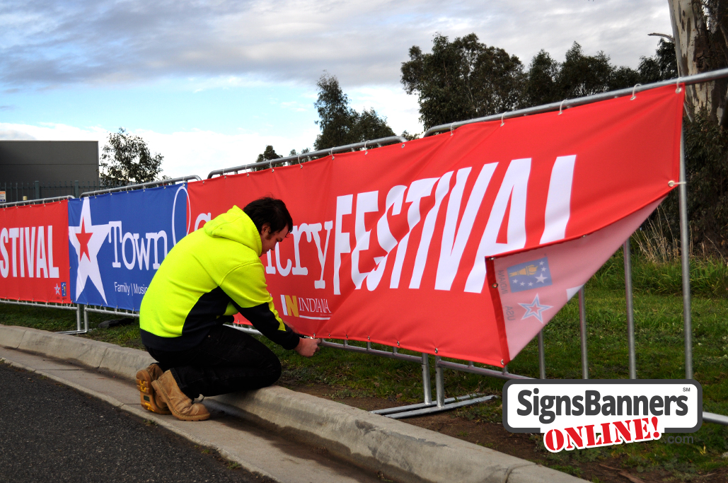 Shows the best technique for mounting banner signs onto barricade style fences as used at events and festivals usa.