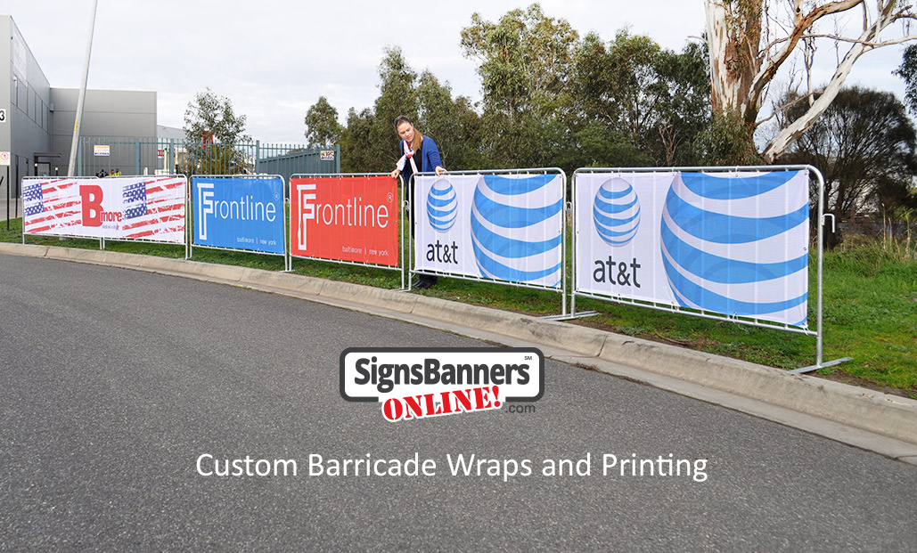 Custom barricade wraps (banner signs fitted to crowd control fence systems) set up on the street ready for an event.