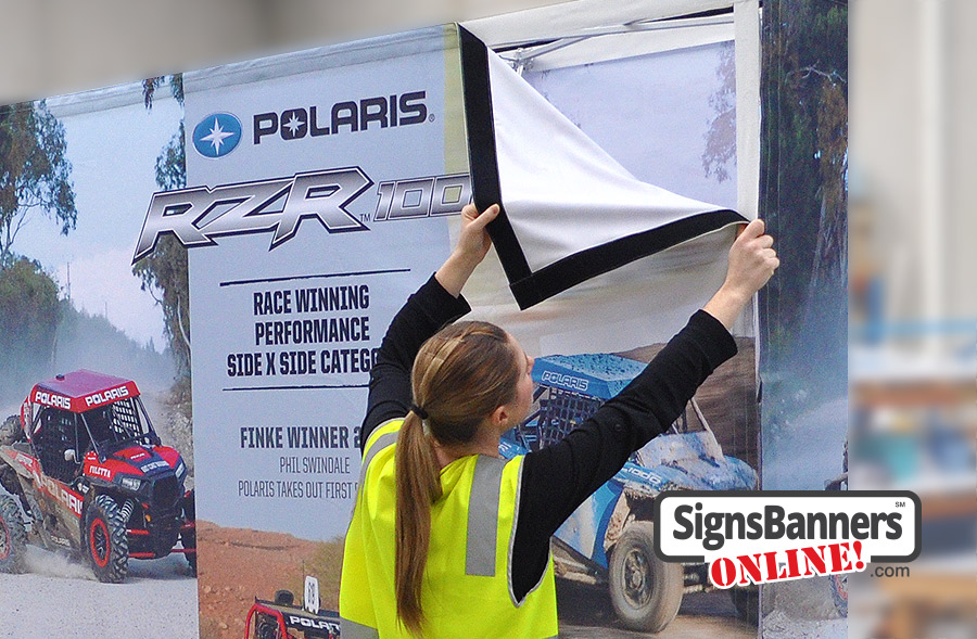 Quick application of the printed fabric display sign banner onto a upright media wall.