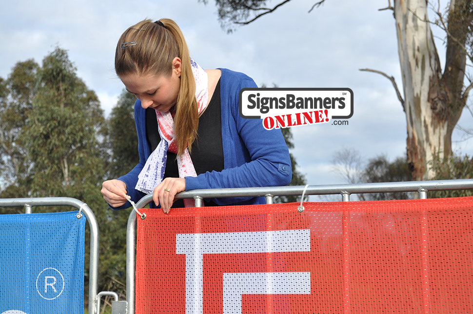 Event signage printing on the corner of the portable barricade being tied using a cable tie commonly known as Zip Tie