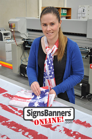 Person female. Model inside printing factory wearing US flag scarf design and presenting the services of banner printing from the factory.