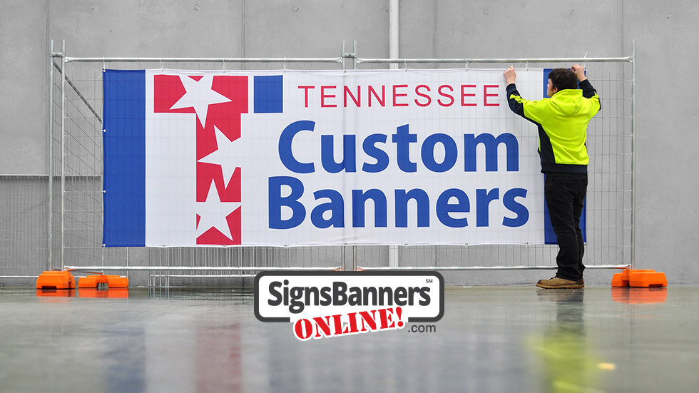 Tennessee custom banners, workman standing next to the Tennessee banner on the upright metal frame.