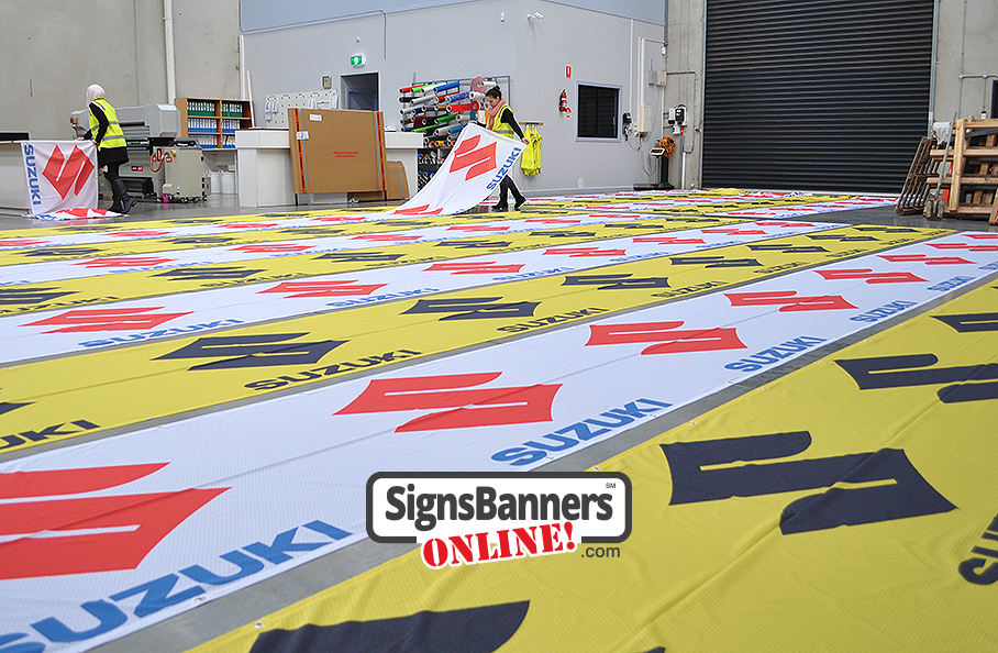 Lots of printed Suzuki banner signs being factory made ready to ship out